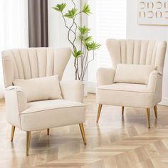 two white chairs sitting next to each other on top of a hard wood floor