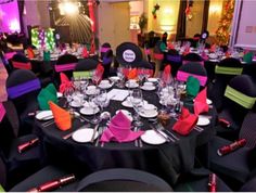 the tables are set with black linens and bright colored napkins for an event