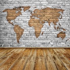 an empty room with a brick wall and wooden floor in front of it is a world map painted on the wall