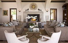 a living room filled with furniture and a fire place in the middle of a room