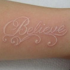 a woman's arm with the word believe written on it in cursive writing