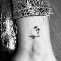 a small palm tree tattoo on the side of a woman's ankle and foot