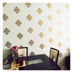 a dining room table with two chairs and a vase filled with flowers