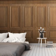 a bedroom with wood paneled walls and white bedding in the foreground is a small table with flowers on it