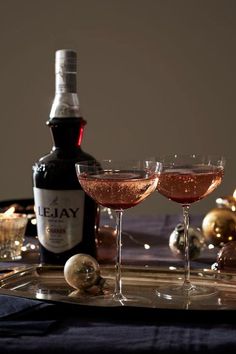 two glasses filled with wine sitting on top of a tray