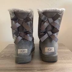 Soft Fuzzy Grey, Two Grey Bows On The Back Of Each Shoe. Ugg Brand. Worn, But In Fantastic Condition. Shoes Uggs, Grey Uggs, Cute Uggs, Grey Ugg Boots, Uggs With Bows, Fuzzy Boots, Bow Boots, Ugg Bailey, Womens Uggs