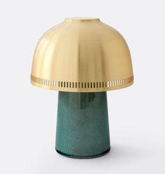 a green and gold table lamp on a white background