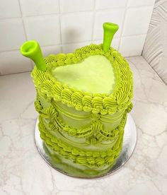 a green cake sitting on top of a white counter