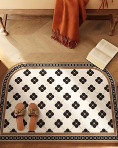 a pair of slippers sitting on top of a rug next to a book and chair