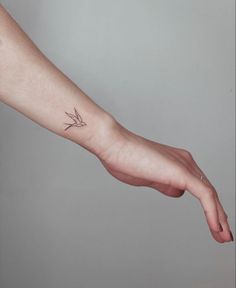 a person's arm with a small tattoo on it