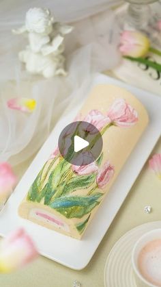 a plate with flowers painted on it next to other plates and utensils in the background