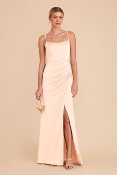 a woman in a long peach dress with a slited skirt and side slits