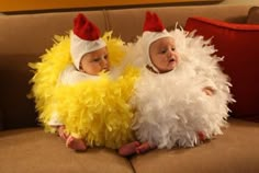 two babies dressed up like chicken suits sitting on a couch