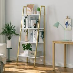 a living room with a white couch and book shelf in the corner next to a window