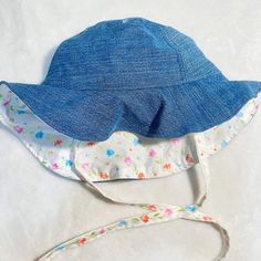 Denim Blue Reversible Bucket Hat 🌷 SIZE ~ 12-2T months. ~ 40-48 cm head size  ~Accessorize your little one with this cute denim and  cotton hat while also giving them sun protection. 🌤️ FEATURES ~reversible side in cotton pattern  ~tieable straps ~optional patch to denim side  CHOOSE # ACCORDING TO IMAGE LISTED ~ 6cm sturdy brim ~lined to hide all seams for comfort Sewn one of a kind in California 🧵🪡 feel free to message me with any questions concerning size Adjustable Fit Hats For Playtime In Spring, Spring Adjustable Fit Hat For Playtime, Spring Adjustable Hats For Play, Cotton Sun Hat For Spring Playtime, Spring Cotton Sun Hat For Playtime, Spring Playtime Cotton Sun Hat, Cute Cotton Sun Hat For Playtime, Cute Adjustable Fit Sun Hat For Spring, Cute Cotton Hats For Birthday