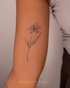 a woman's arm with a flower tattoo on the left side of her arm