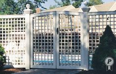 an outdoor pool with a white fence and trees