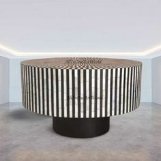 a round table with black and white stripes on it in the middle of a room