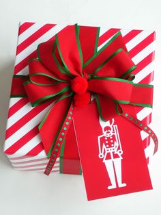 two presents wrapped in red and white paper with green ribbons on them, tied together