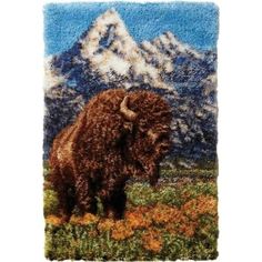 an image of a bison standing in the grass with mountains in the backgroud