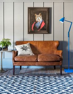 a living room with a couch, lamp and painting on the wall