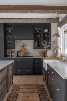 a kitchen with gray cabinets and white counter tops, an area rug on the floor