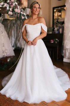 a woman in a white wedding dress posing for the camera