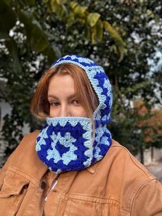 a woman wearing a blue and white crocheted scarf with a hood on her head