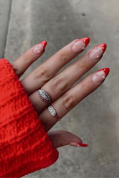 35 Iconic Almond Christmas Nails to Slay the Season Red French And Pearls, Red Christmas Nails With Pearls, Red French Tip Nails Almond With Pearls, Summer Red French Nails, Red Tip With Chrome, Red French With Diamonds, Red Tips Christmas Nails, Red Nails With Pearls On Them, Red Tip Nails With Pearls