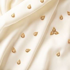 the white fabric has gold leaf designs on it