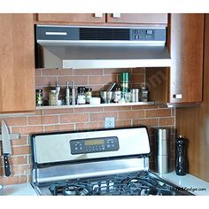 a stove top oven sitting inside of a kitchen next to wooden cupboards and cabinets