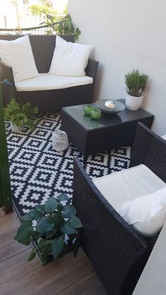 an outdoor patio with black wicker furniture and potted plants on the balcony area