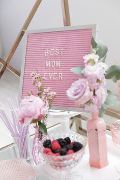 a bowl of berries and raspberries sits next to a sign that says best mom ever