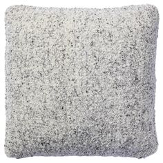 a gray and white pillow on a white background, with small speckles all over it