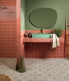 a bathroom with pink tiles and green walls