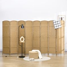 a room divider made out of wicker with a lamp on the floor next to it