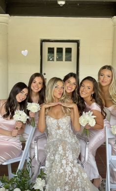 the bridesmaids pose for a photo in their pink dresses