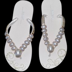 a pair of white sandals with pearls on them