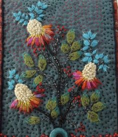 a close up of a piece of cloth with flowers on it and beads in the middle