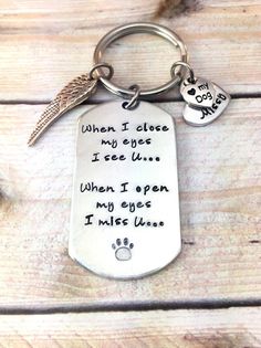 a keychain with a dog's paw on it that says when i close my eyes, i see u when i open my eyes i miss you