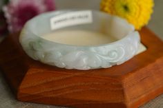 ♡This is a Natural Grade A Burmese (Myanmar) Glutinous ice Hand Carved Jadeite bangle, with a little green and yellow color(has a certification in China). ♡ Carved pattern：花開富貴，flower, leaf（meanings Bloom and prosper） ♡It's a finished product, you can get the style and color from the picture. ♡ The bangle Size: Inner diameter 58mm，Width14.4mm, thickness8.7mm. ♡Please note the original colors may be a little bit different from what you see on your monitor. ♡Postal services to certain destinations White Carved Bracelets, White Carved Round Bracelet, Carved Jade Bangle As A Gift, Handmade Round Jade Bangle, Leaf Meanings, 100 Grade, Baby Bangles, Flower Leaf, Free Bracelet