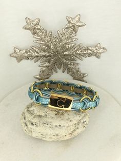 two bracelets on top of a rock next to a snowflake