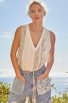 Designed in V-neck line oversized fit sleeveless knit top with rib and floral printed woven and trim. Handkerchief hem. Summer V-neck Knit Top For Day Out, Spring V-neck Knit Top For Day Out, Bohemian V-neck Tops For Layering, Bohemian Sleeveless Knit Top For Spring, Bohemian Knit Top For Summer Day Out, Bohemian V-neck Tank Top For Spring, Chic Sleeveless Top With Crochet Trim, Sleeveless Knit Top For Spring Vacation, Bohemian Sleeveless Knit Top For Summer