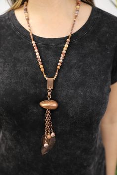 Our Fortuna necklace is a fantastic piece for the lover of vintage or nature inspired jewelry. This handmade necklace combines matte birdseye rhyolite stone beads, vintage elements, and bronze cable chain. From the rhyolite bead necklace hangs a tassel of chain and beads, a vintage stone-like pendant and a vintage feather charm. It is named for Fortuna, the goddess of fortune. A matching bracelet is available. Features: - Vintage Elements - Matte Birdseye Rhyolite - Cable Chain in Bronze - Leath Bohemian Brown Electroformed Necklaces, Vintage Copper Necklaces, Vintage Brown Necklace With Adjustable Chain, Bronze Bohemian Necklace With Natural Stones, Bronze Necklaces With Wooden Beads For Jewelry Making, Bohemian Brown Copper Necklaces, Earthy Bronze Copper Necklaces, Spiritual Brown Brass Necklace, Brown Brass Spiritual Necklace