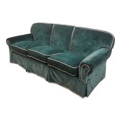 a green velvet sofa with two pillows on it's back and the arms folded down