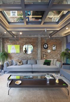 a living room with couches, tables and mirrors on the wall in it's center