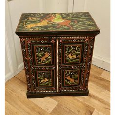 an ornate painted wooden cabinet on the floor