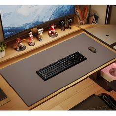 a desk with a keyboard, mouse and various figurines sitting on top of it