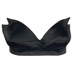 Presenting a stunning black satin Thierry Mugler pointed bralette, designed by Manfred Mugler. From the 1980s, this bralette is constructed entirely of shiny black satin. The bralette features a sweetheart cut and is made complete with pointed accents on either cut, giving this bralette an undeniable Mugler touch. A must-have for any Thierry Mugler lover, this bralette can be sported on its own or layered with your favorite blazer. Approximate measurements: Size - 42FR Top of bust to hem: 5" Bus Elegant Satin Crop Top For Evening, Elegant Satin Crop Top For Party, Chic Silk Crop Top For Evening, Satin Evening Crop Top, Party Satin Crop Top With Built-in Bra, Elegant Low-cut Crop Top For Party, Fitted Satin Bra With Removable Pads, Summer Party Satin Bra, Summer Evening Satin Crop Top