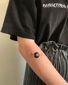 a person with a tattoo on their arm holding a black object in the other hand